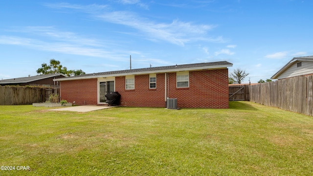 back of property with central air condition unit, a lawn, and a patio