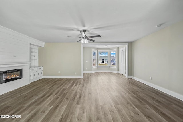 unfurnished living room featuring ceiling fan and hardwood / wood-style flooring