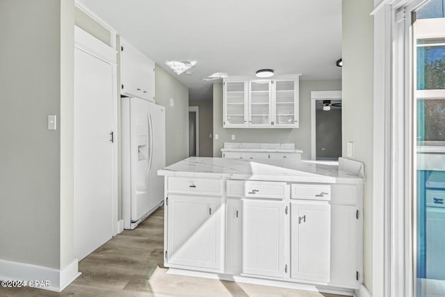 kitchen with white fridge with ice dispenser, white cabinets, and light wood-type flooring