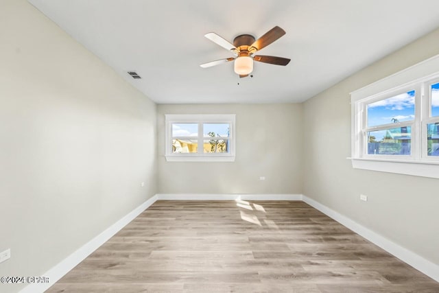 empty room with ceiling fan, light hardwood / wood-style floors, and a wealth of natural light