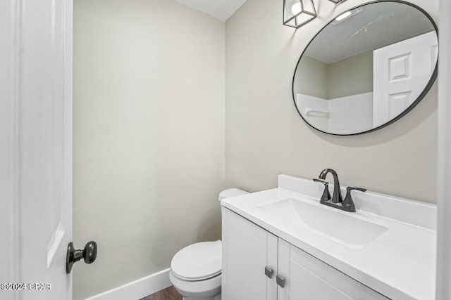 bathroom with hardwood / wood-style floors, vanity, and toilet