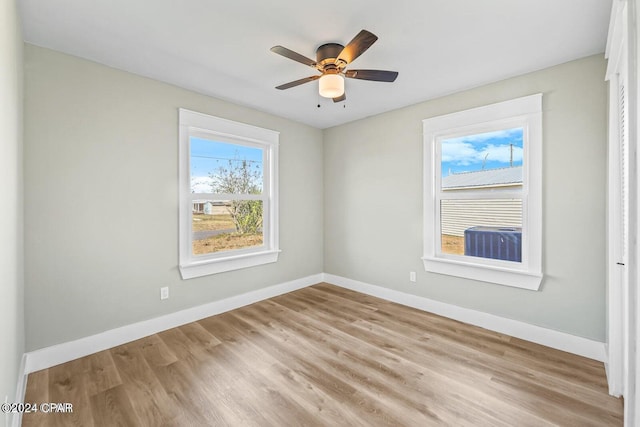 spare room featuring ceiling fan, light wood-type flooring, and plenty of natural light