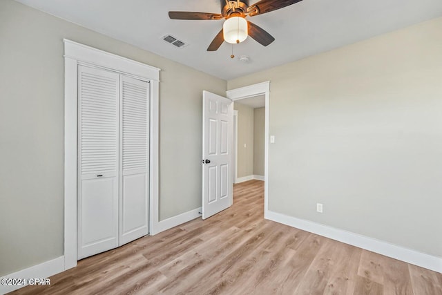 unfurnished bedroom featuring ceiling fan, light wood-type flooring, and a closet