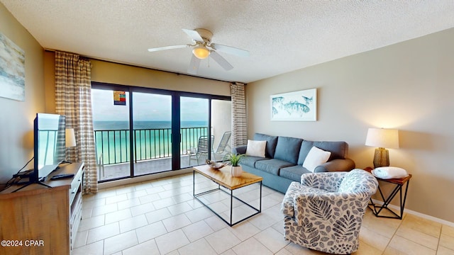 living room featuring a textured ceiling, ceiling fan, and light tile patterned floors