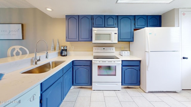 kitchen with light tile patterned floors, white appliances, sink, and blue cabinetry