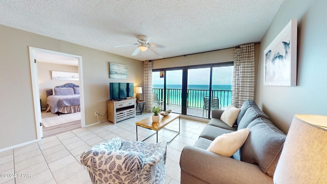 living room with a textured ceiling, light tile patterned floors, and ceiling fan