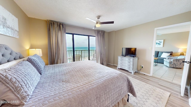 bedroom with ceiling fan, a textured ceiling, access to outside, and light hardwood / wood-style flooring