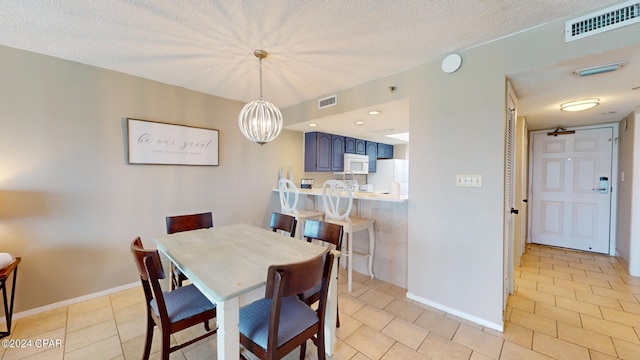 tiled dining room featuring a textured ceiling