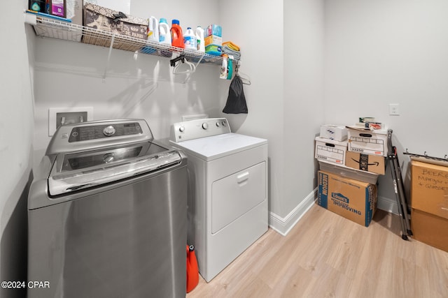 washroom featuring light hardwood / wood-style flooring and washing machine and clothes dryer