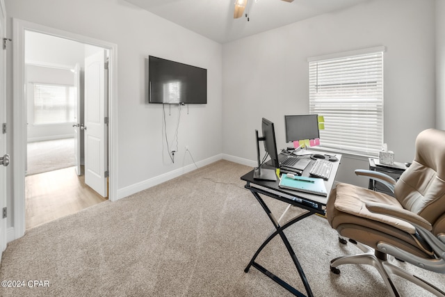 carpeted office space with ceiling fan