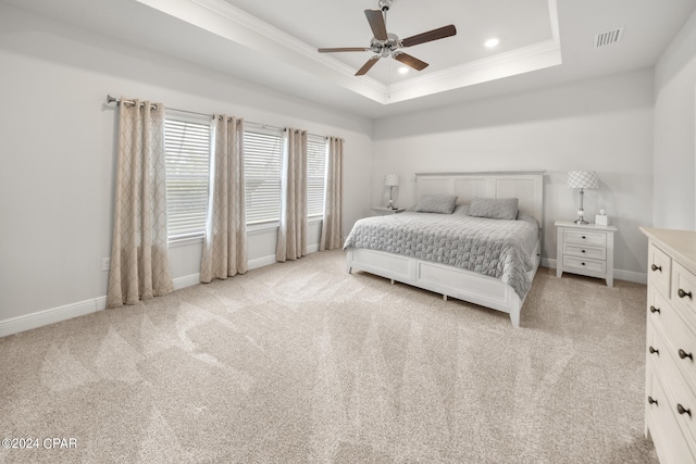 bedroom featuring ornamental molding, ceiling fan, a tray ceiling, and light colored carpet