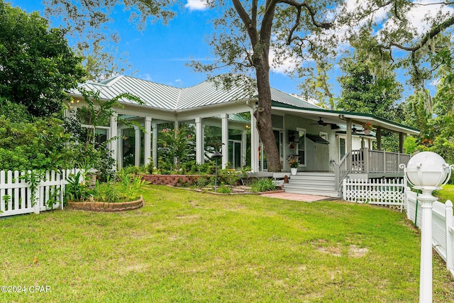 view of front of home with ceiling fan and a front lawn