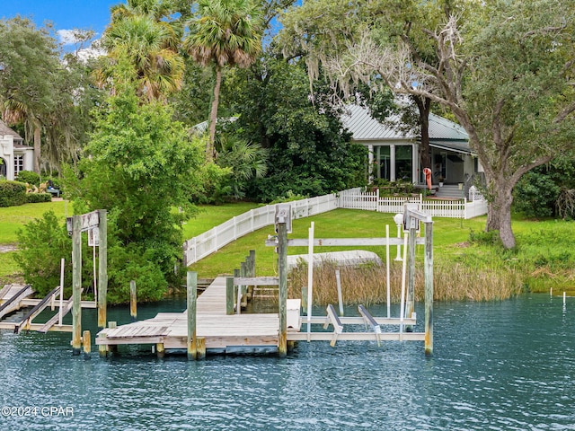 dock area featuring a lawn and a water view