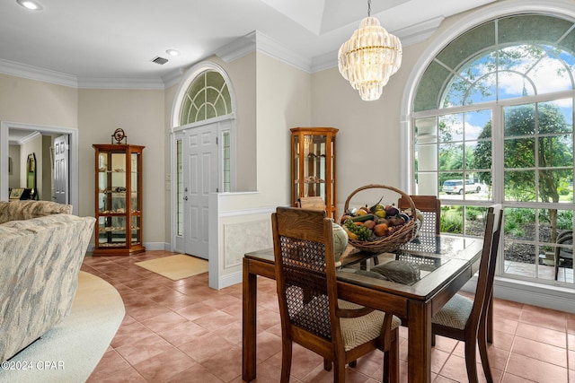 dining space featuring crown molding, light tile patterned flooring, and a notable chandelier