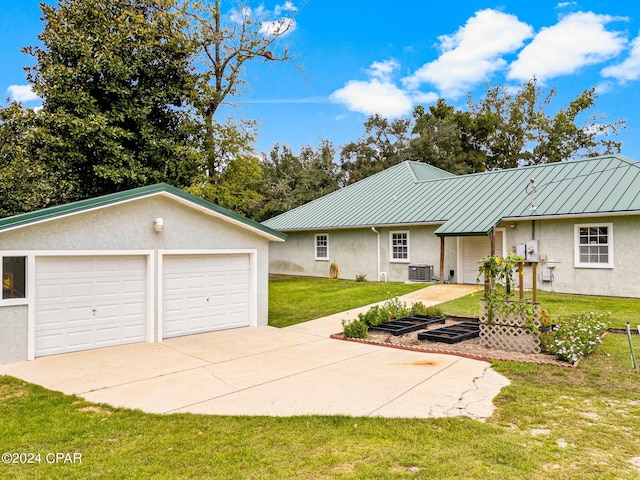 exterior space featuring a front lawn, central AC unit, and a garage