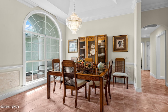 tiled dining area with ornamental molding, a chandelier, and a wealth of natural light