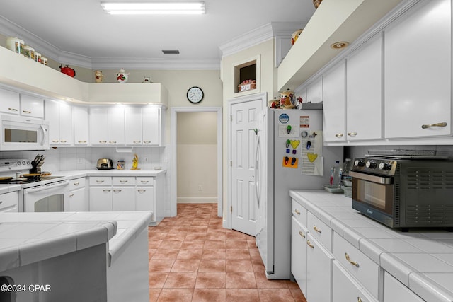 kitchen featuring decorative backsplash, white cabinets, white appliances, and tile countertops