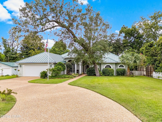 ranch-style house with a garage and a front lawn