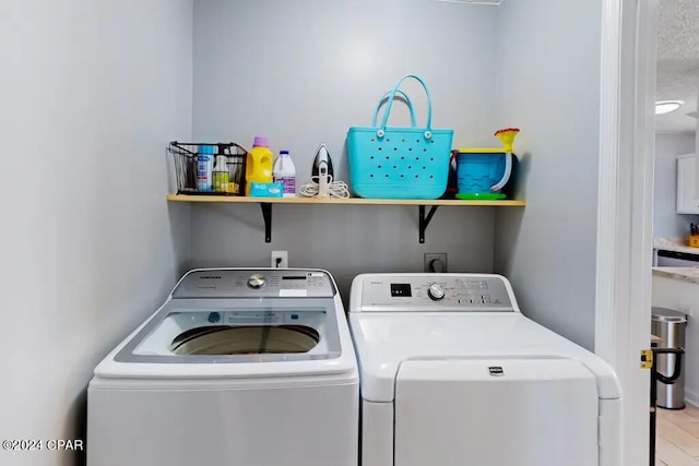 clothes washing area featuring light hardwood / wood-style flooring and separate washer and dryer