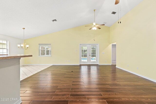 living room featuring french doors, high vaulted ceiling, dark wood-type flooring, and ceiling fan with notable chandelier