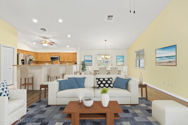 living room featuring ceiling fan with notable chandelier and lofted ceiling