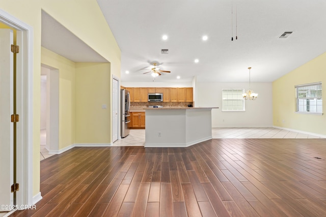 unfurnished living room featuring dark wood-type flooring and ceiling fan with notable chandelier