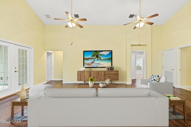 unfurnished living room with ceiling fan with notable chandelier, high vaulted ceiling, and dark hardwood / wood-style floors