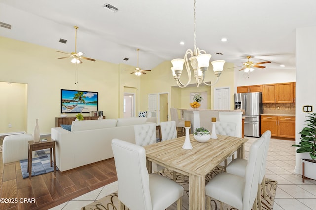 dining area with light tile patterned flooring, a chandelier, and vaulted ceiling