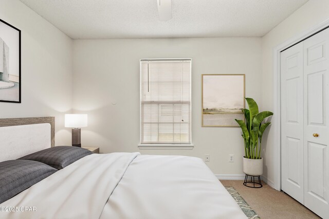 carpeted bedroom featuring a closet and ceiling fan