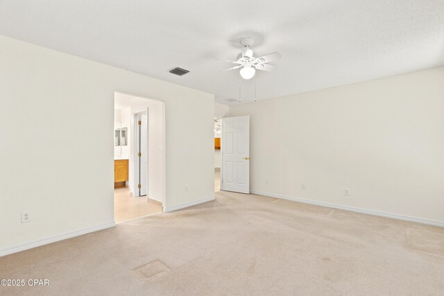 empty room with a textured ceiling, light colored carpet, and ceiling fan