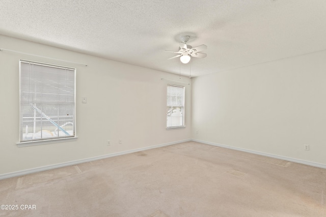 carpeted spare room featuring ceiling fan and a textured ceiling