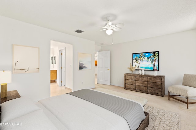 bedroom with light carpet, ceiling fan, and ensuite bath