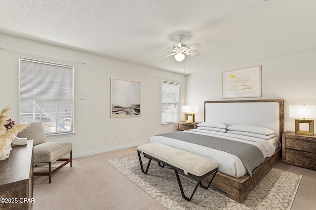 bedroom featuring ceiling fan, light colored carpet, and a textured ceiling