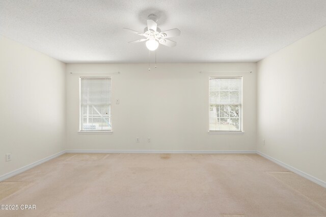 unfurnished room featuring ceiling fan, a textured ceiling, and light colored carpet