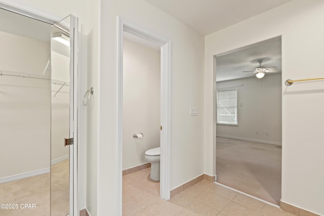 bathroom with toilet, tile patterned flooring, and ceiling fan