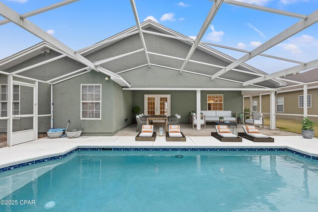 rear view of house featuring a patio, an outdoor living space, french doors, and glass enclosure