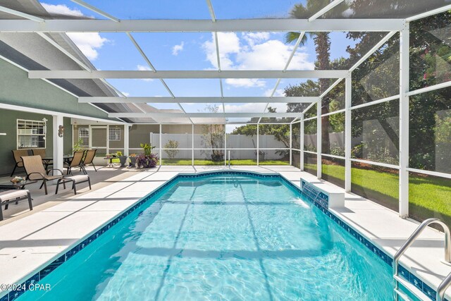 view of swimming pool featuring a patio area and a lanai