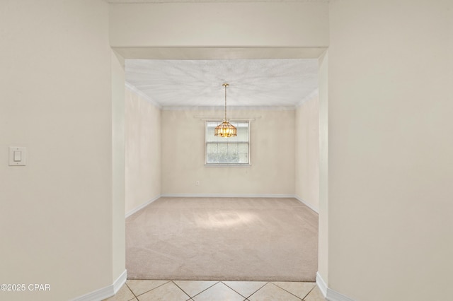 unfurnished room with light tile patterned floors, crown molding, and a chandelier