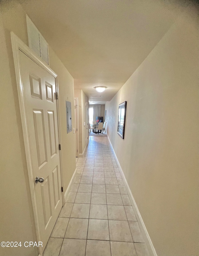 hall featuring electric panel and light tile patterned flooring