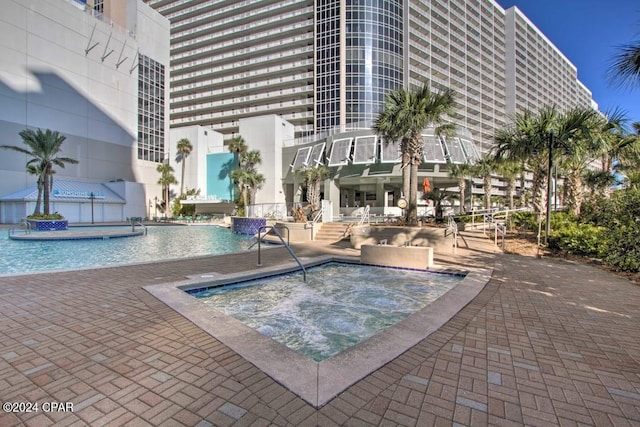 view of swimming pool featuring a hot tub and pool water feature