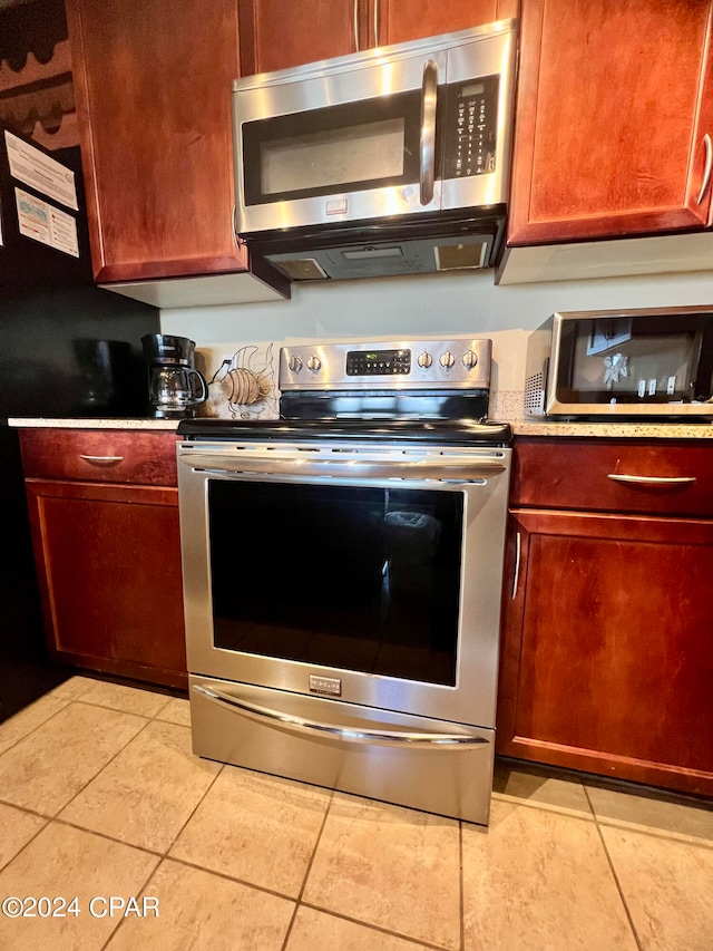 kitchen with light tile patterned floors and appliances with stainless steel finishes