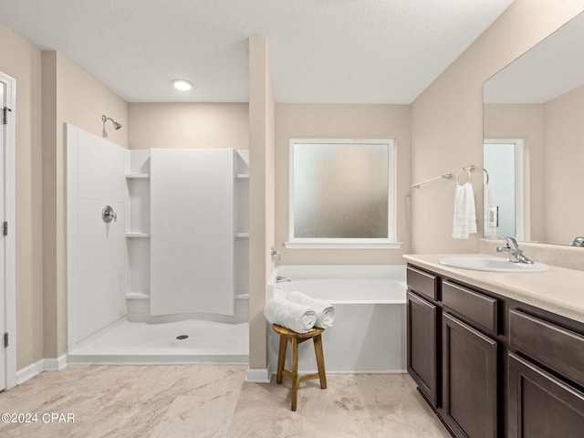 bathroom with vanity, shower with separate bathtub, and a textured ceiling