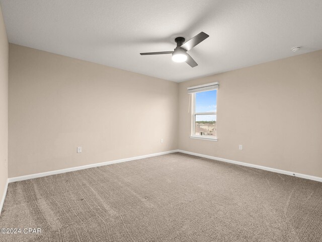 carpeted spare room featuring a textured ceiling and ceiling fan