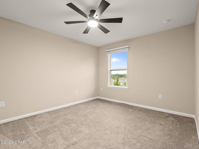 carpeted spare room featuring ceiling fan