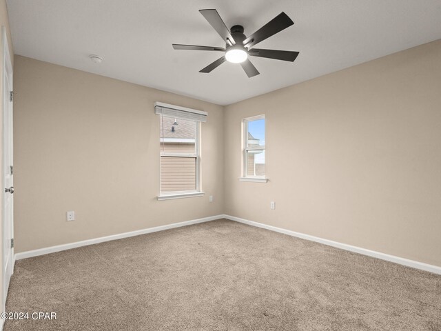 carpeted spare room featuring ceiling fan