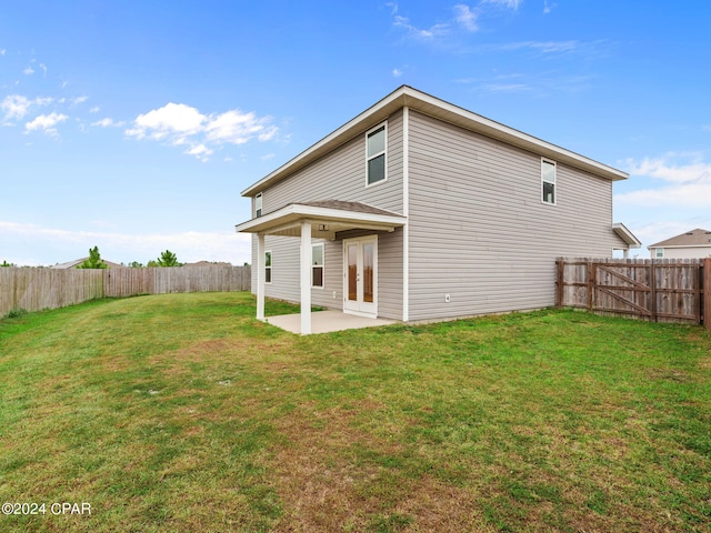 back of property featuring a patio area and a lawn