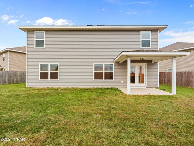 rear view of property featuring a patio and a yard