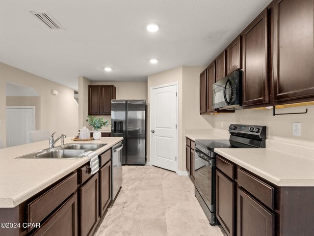 kitchen with an island with sink, sink, dark brown cabinetry, and black appliances