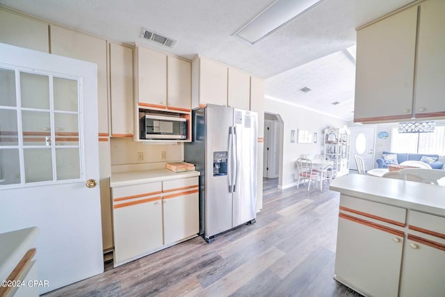 kitchen with appliances with stainless steel finishes, a textured ceiling, and light wood-type flooring