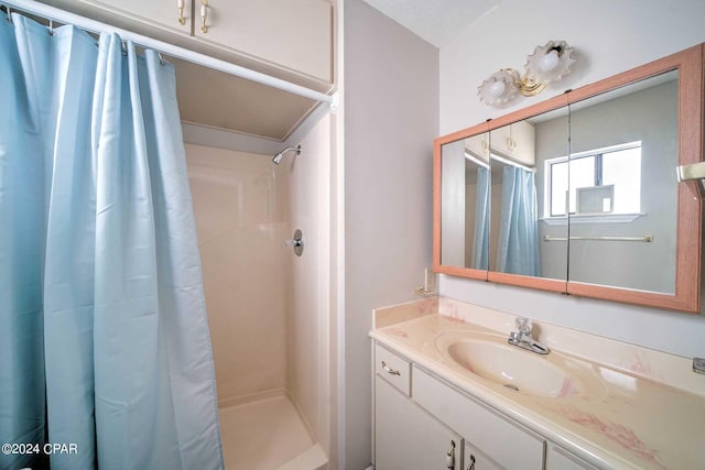 bathroom with vanity, a textured ceiling, and a shower with shower curtain